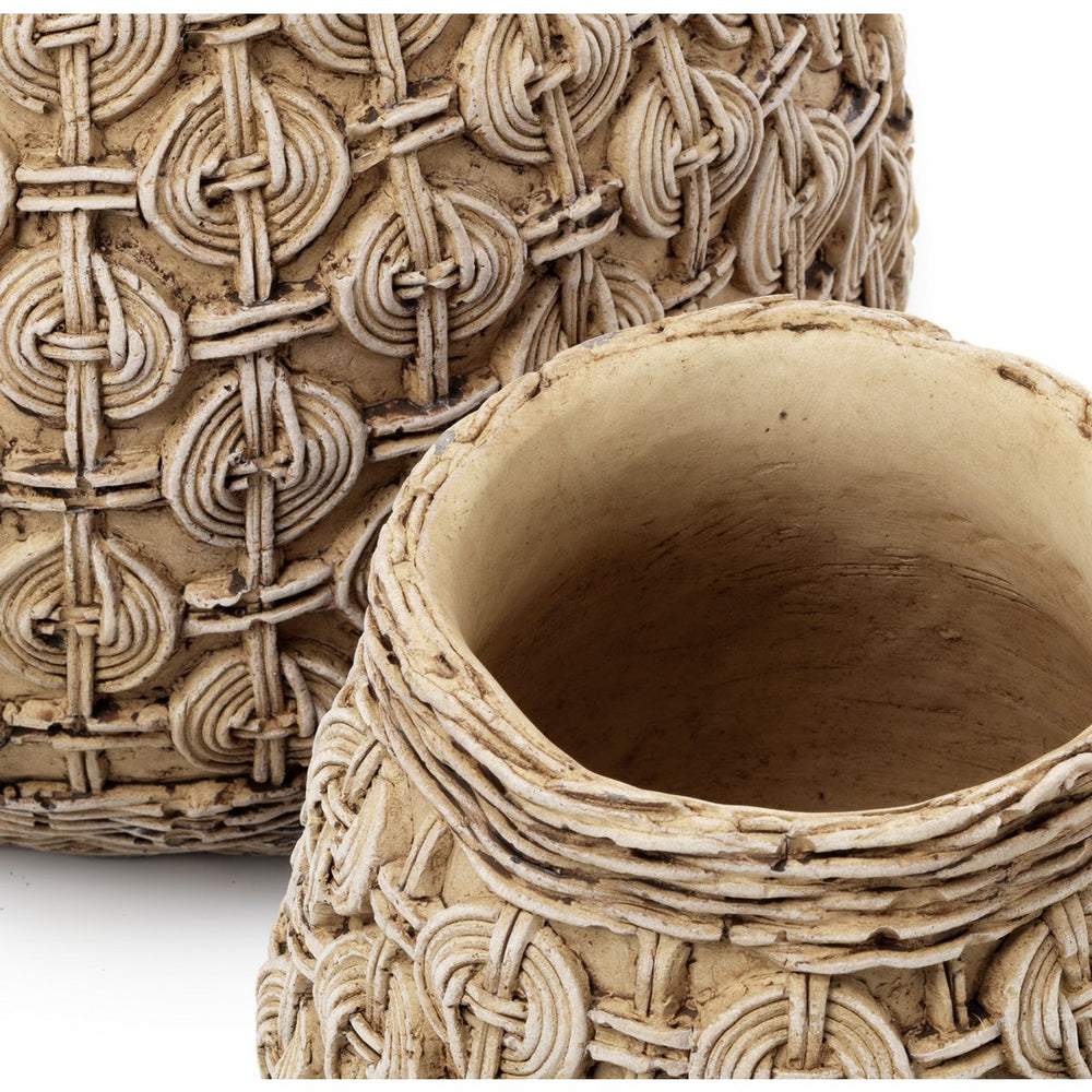 Close-up of a textured ceramic pot with intricate patterns on a white background