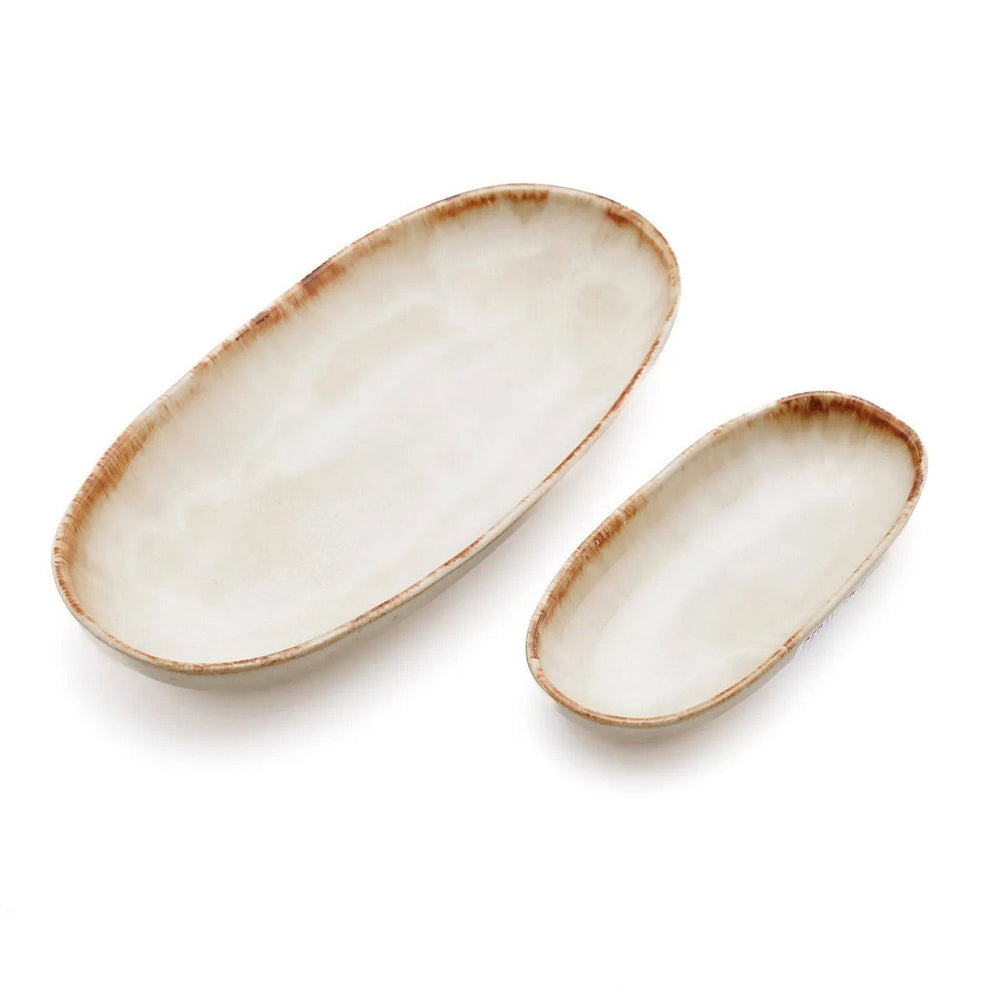 Two oval ceramic plates with brown edges on a white background