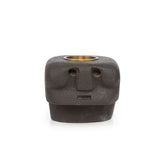 Ceramic face-shaped candle holder with a brass interior on a white background