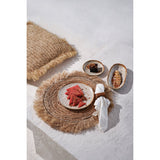 Rattan placemat with a plate of food on a light surface